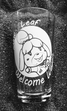 16oz pint glass with image of Isabelle from Animal Crossing in a circle. She is smiling and her arms are open to give you a hug. Around the circle are the words 