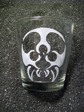 Load image into Gallery viewer, An extra large shot glass that is etched with a tattoo-style metroid monster. It has a round body (no head) with three eyeballs and four fangs. 
