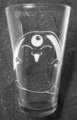 A pint glass etched with Mokona. Mokona has its eyes closed and a big open-mouth smile. His hands are raised. 