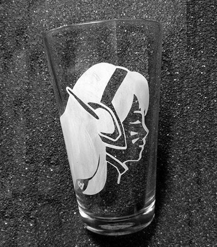 A pint glass etched with D.va's face. She is facing to the right with her eyes closed and her hair streaming behind her. 